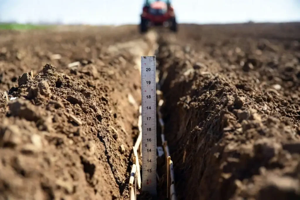ruler showing planting depth in a furrow