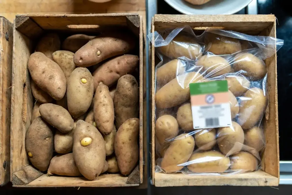 seed potatoes in crate beside store potatoes in a bag