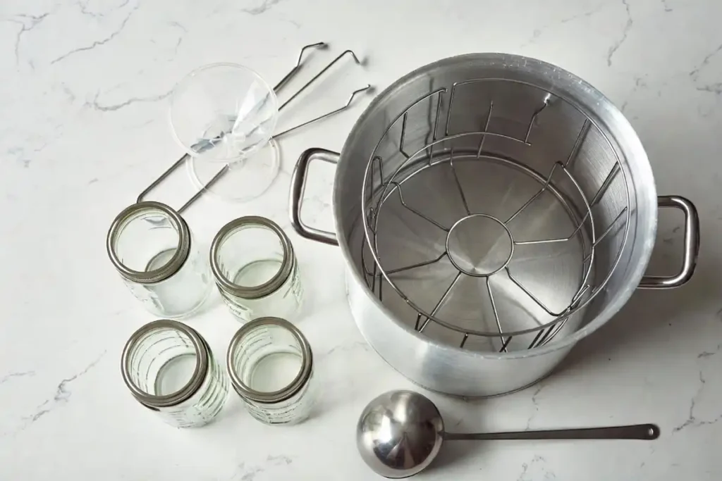 canning pot jar lifter funnel and mason jars on kitchen counter