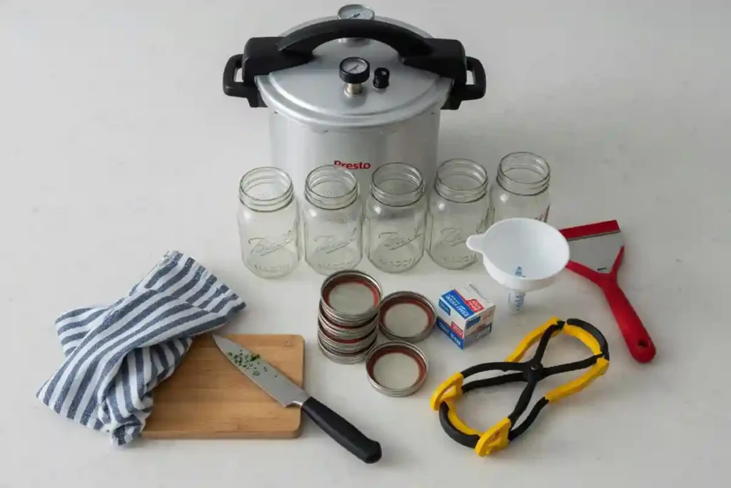 pressure canner and canning jars set up on a kitchen counter for sweet corn