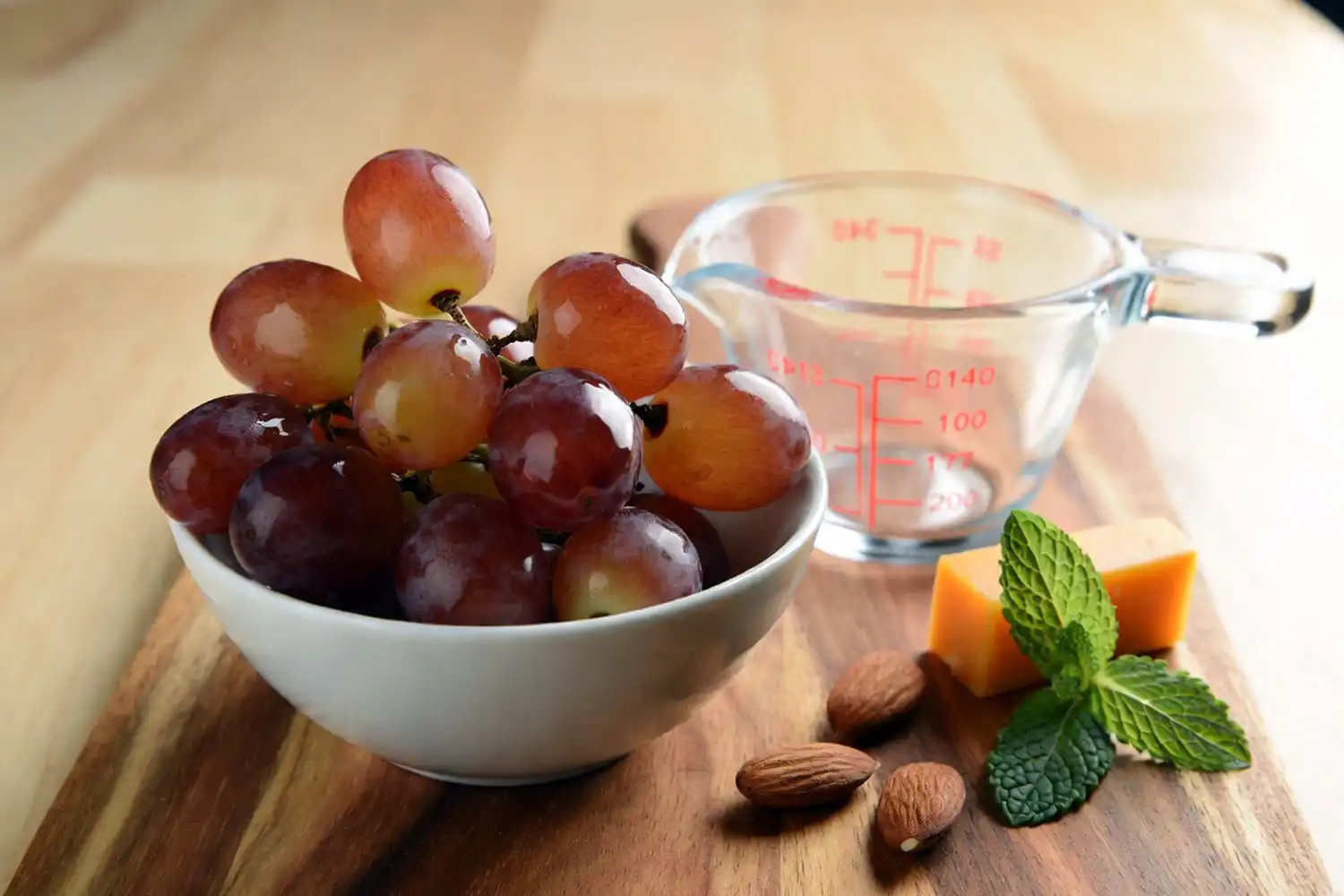 One cup portion of Candy Snap grapes served with cheddar cheese and almonds as a balanced healthy snack