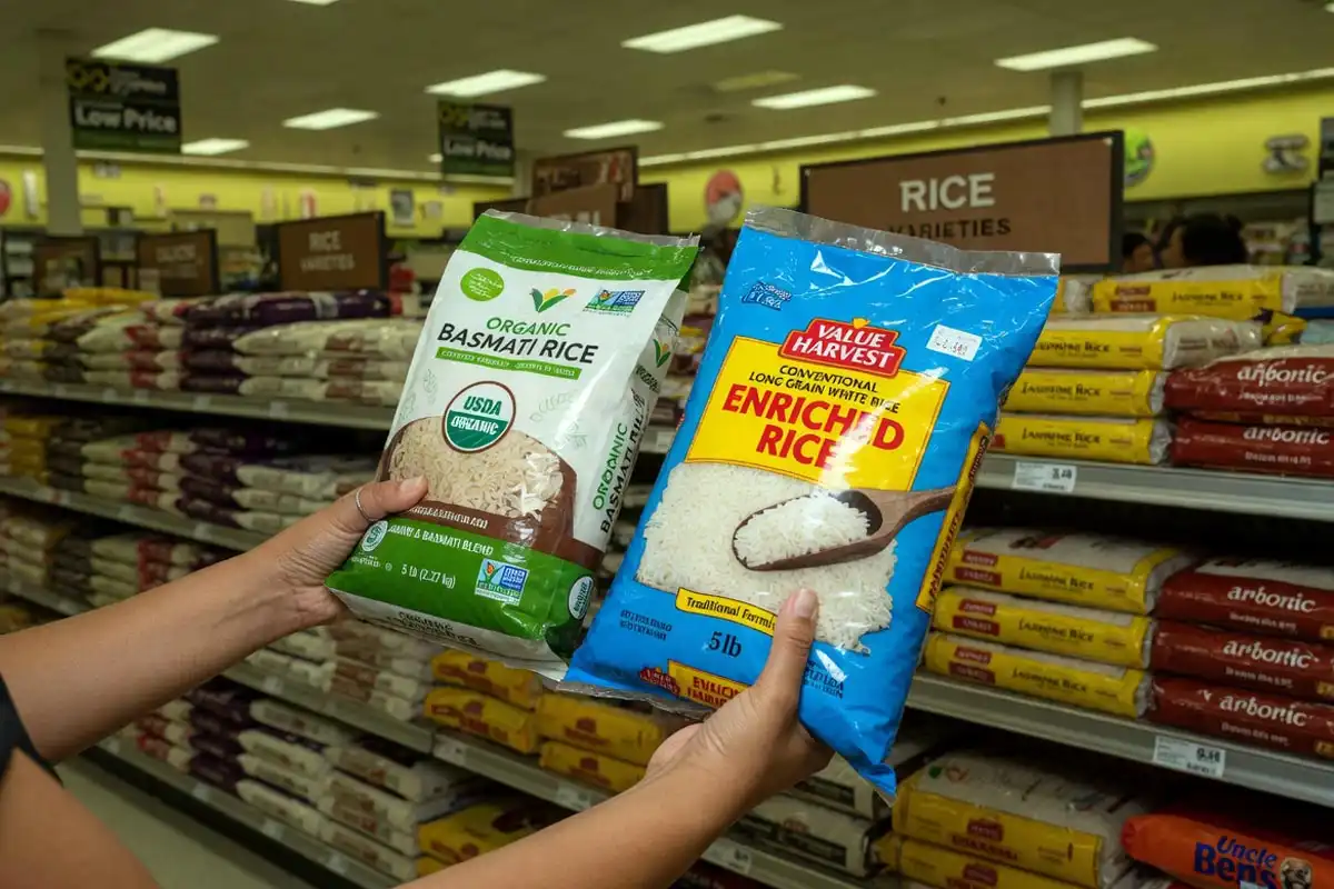 Man holding organic rice and conventional rice bags while choosing at the store