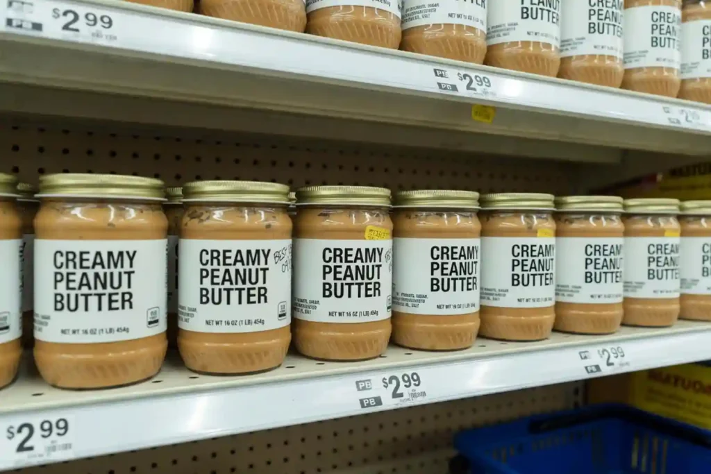 Peanut butter jars lined up on grocery store shelf