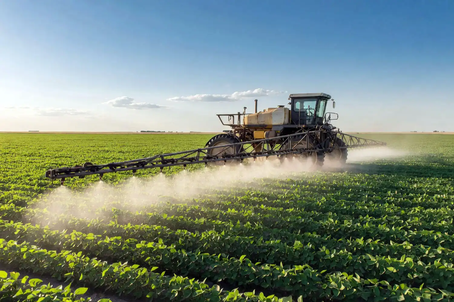 Ground sprayer applying Liberty glufosinate over young soybeans on a sunny day before the R1 cutoff