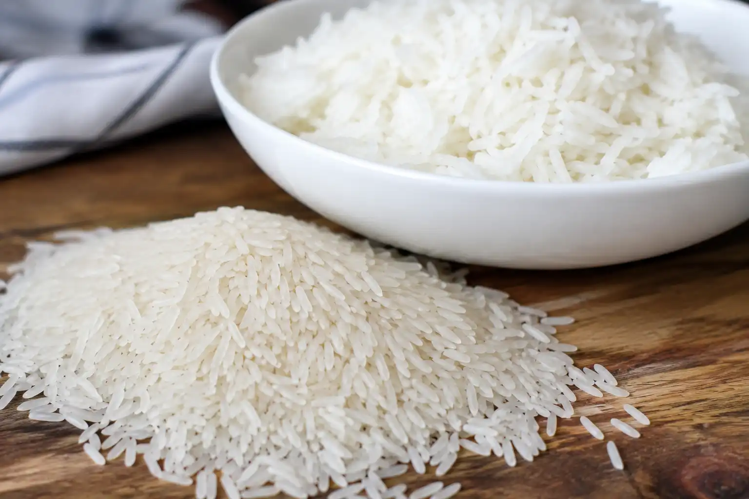 Long grain rice shown as slender raw grains and a bowl of fluffy separate cooked rice